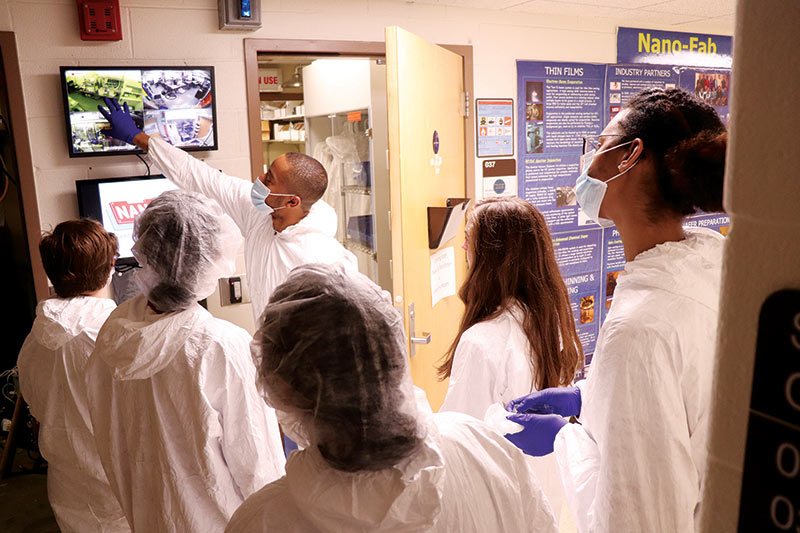 Joshua Burrow explains processes conducted in the Nano-Fab Lab at the University of Dayton during a workshop for high school students attending a women in engineering camp. Photo by Ankita Khanolkar.