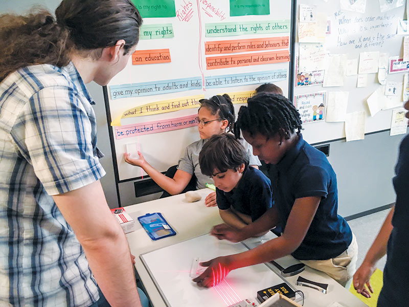 Students during the in-school visit learn about reflection and refraction with a laser box kit. Photos courtesy of CSU SPS chapter.