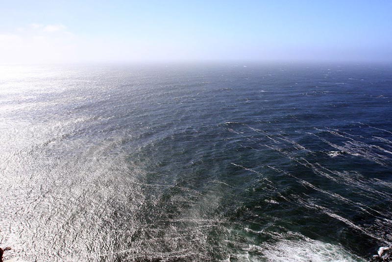 Waves are diffracted around a rocky outcrop. Photo by Wing-Chi Poon.