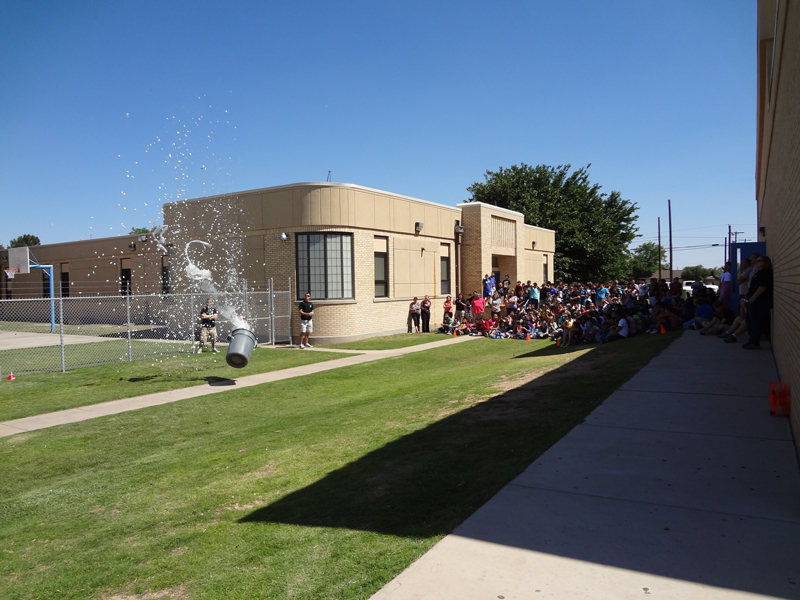 Water and packing peanuts erupt from a trash can during a Peer Pressure demonstration