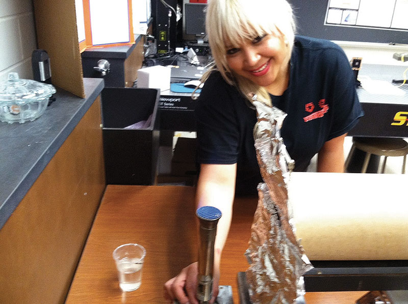 Team member Susan Salazar lights and adjusts a Bunsen burner during a run of the Hertzsprung-Russell diagram experiment.