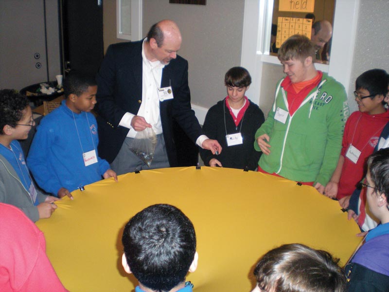 Gary White uses spandex and marbles to demonstrate the properties of gravity during an outreach event at the 2013 AAPT Winter Meeting. Photo by Lydia Quijada.