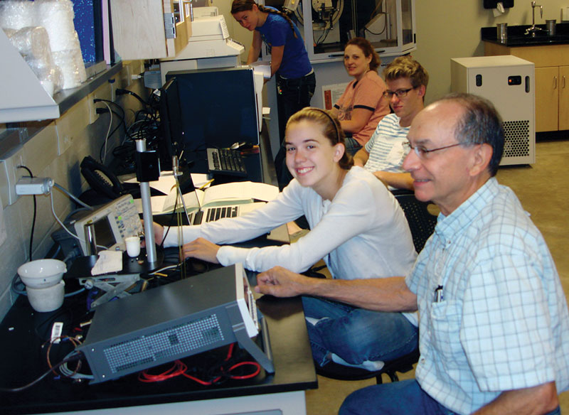 The author adjusts an oscilloscope in her laboratory at Coe College. Photo by Steven Feller.