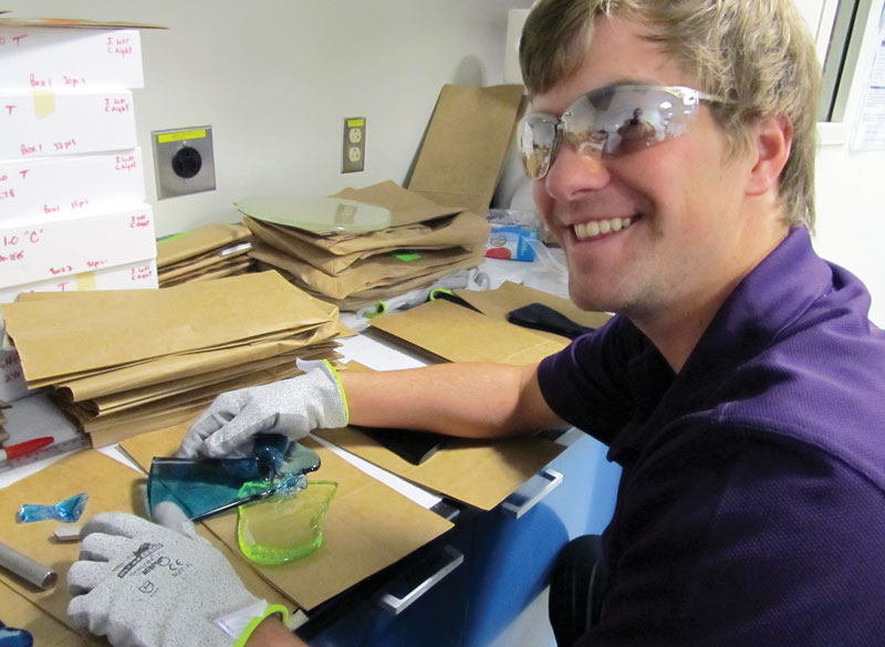 The author tests a glass sample in the lab. Photo courtesy of Ethan Lawrence.