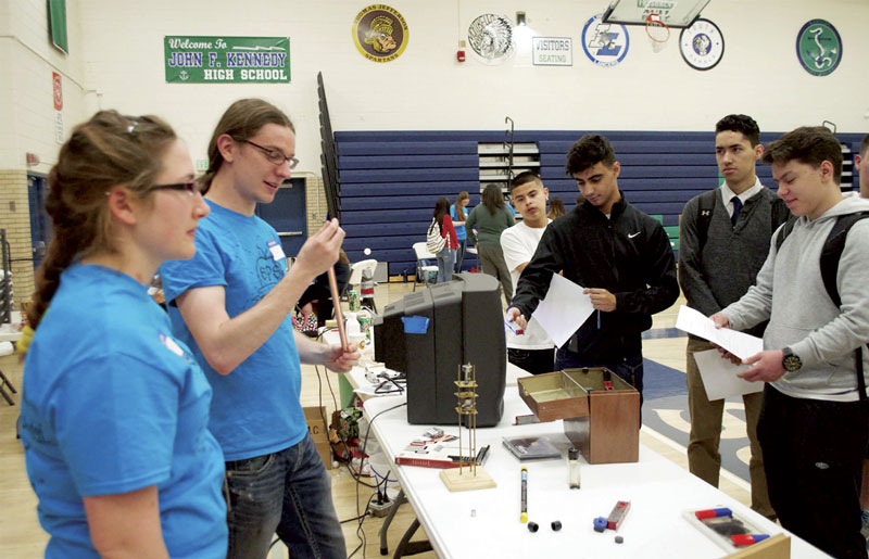 Allison Tucker and Nick Smith explain Lenz’s law and the ideas of eddy currents to a group of students. Photo by Fran Mallett.