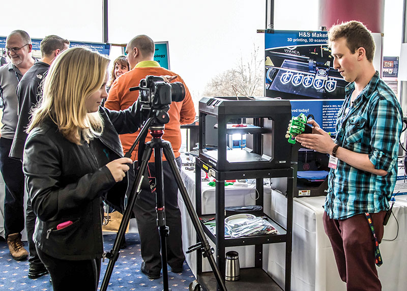 Ithaca College physics major Ryan Bouricius demonstrating a 3-D printed prosthetic hand at Ithaca College’s Educational Technology Day. Ryan’s senior physics thesis focused on modifying a design obtained from eNable to give the thumb and fingers additional orientations to make the hand more functional. Educational Technology Day at Ithaca College is a free regional event that attracts 1,600 educators and technology specialists to learn about the latest trends in educational technology. Professor Rogers and the Ithaca College SPS chapter share their 3-D laser scanning and printing educational efforts at this event each year.  Photo by teacher-in-residence Marty Alderman.