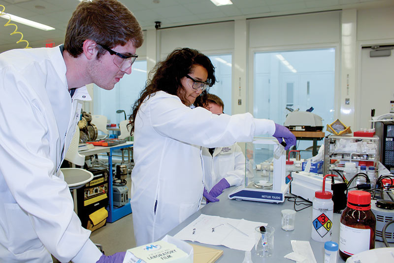 Undergraduate research students Wyatt Liptak, Shirley Garcia, and Dominic Dodson preparing dolomite samples for characterization and cycle life testing using the TGA analyzer. Photo courtesy of Dr. Sesha Srinivasan. 