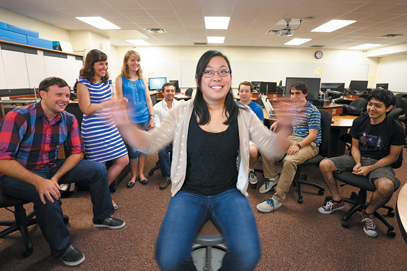 Jackie Chini (second from left) and Learning Assistants at the University of Central Florida explore a favorite active learning demonstration on a spinning stool. Photo by Courtney Shapiro, courtesy of the APS PhysTEC program at UCF.