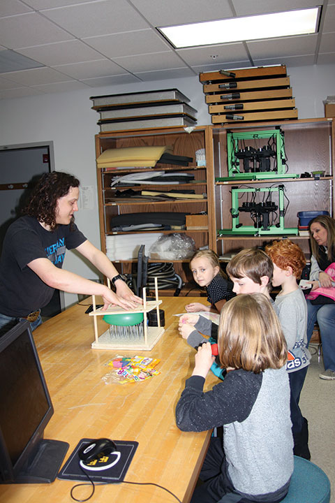 Physicists-in-training watch a bed-of-nails demonstration during an outreach event put on by the Gustavus SPS chapter. Photos courtesy of the Gustavus Adolphus College SPS chapter.