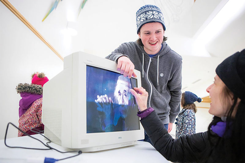 UAF SPS member Matthew Wilhelm demonstrates the deflection of charged particles in a magnetic field using a CRT monitor and a magnet at Astropalooza 2. Photo courtesy of Tanya Clayton.