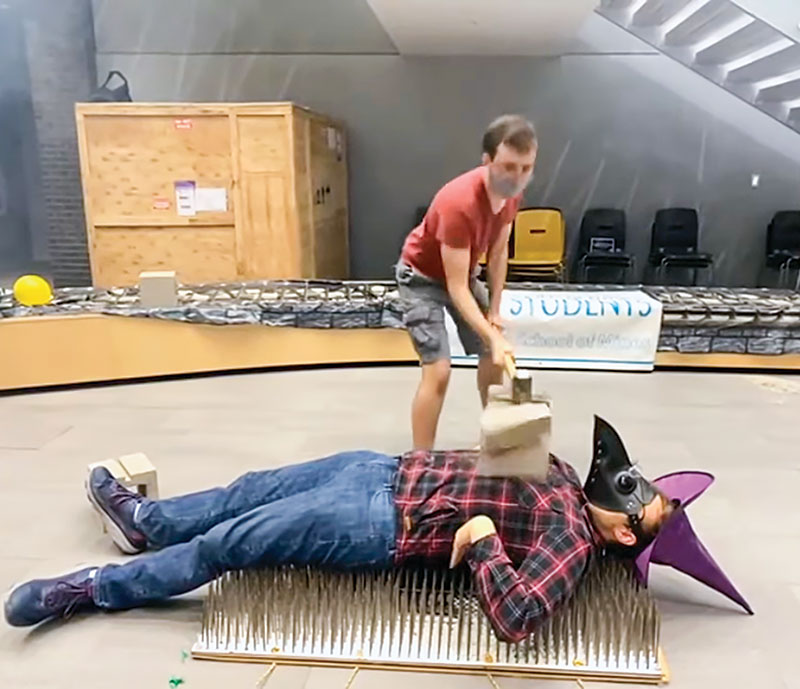 SPS chapter president Josh Lewis demonstrates pressure by laying on a bed of nails while a cinder block is crushed on his chest using a sledgehammer. All photos courtesy of Colorado School of Mines SPS.