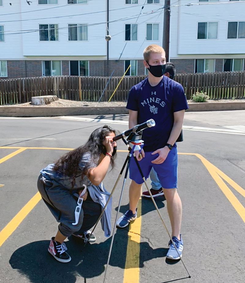 SPS chapter outreach coordinator Austin Holmes conducts an optics demo at a local youth center.