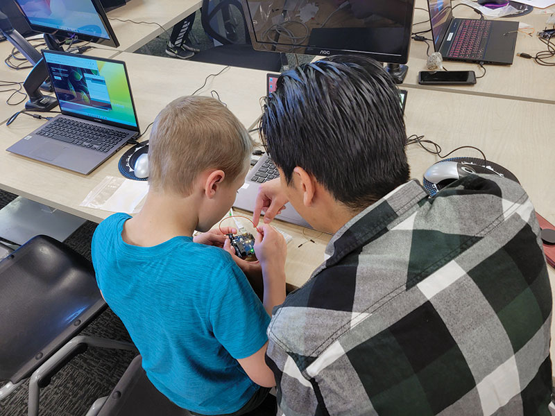 UC Denver SPS members assist kids with building traffic light circuits. Photos by Alya Sharbaugh.