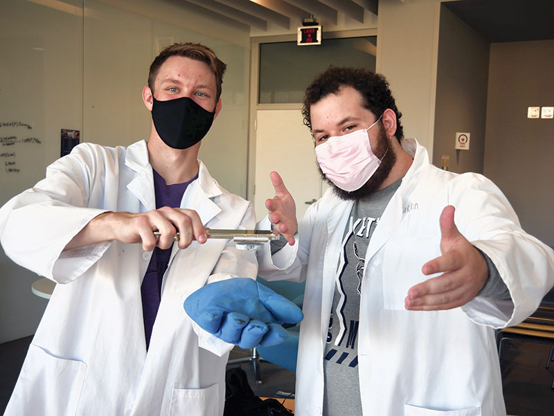 Josh Barbell and PJ Olmsted demonstrate magnetic flux locking by holding a suspended superconducting disk upside down.