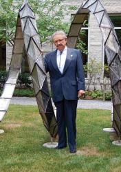 Worth Seagondollar poses by a sculpture at the American Center for Physics following a 2007 invited talk and Q&amp;A about his experiences working on the Manhattan Project. Photo by Tracy Nolis-Schwab.